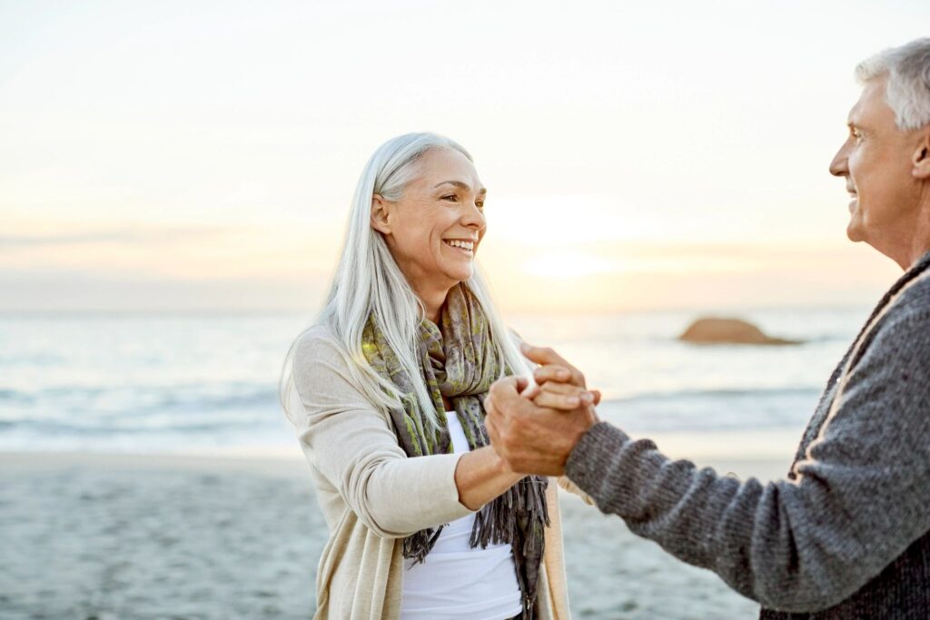 Paar tanzt am Strand bei Sonnenuntergang