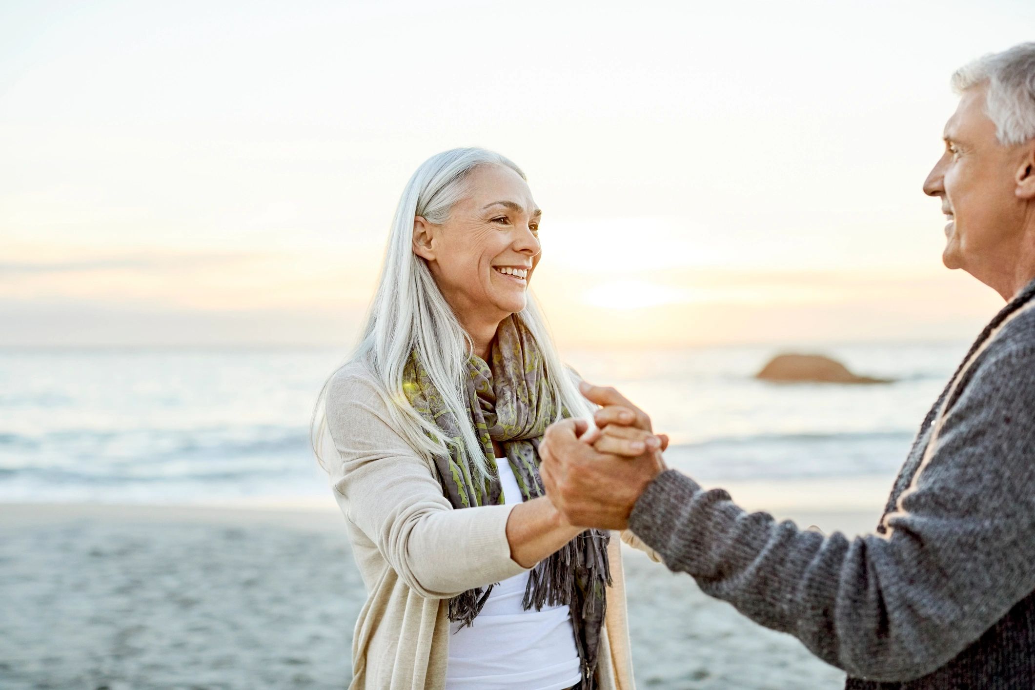 Paar an der Küste bei Sonnenuntergang als Symbolbild für besondere Urlaubsmomente