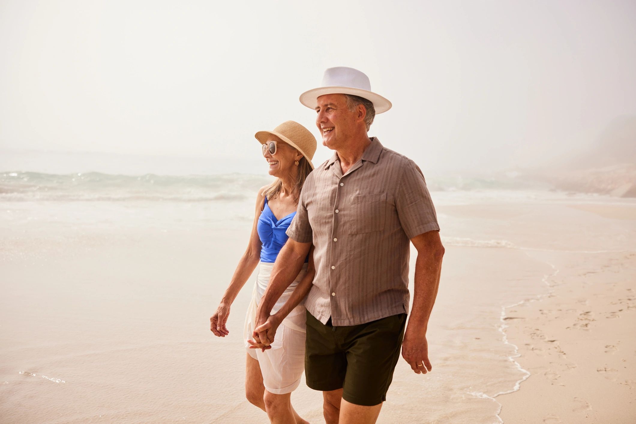 Glückliches Paar am Meer als Symbolbild für positive Reiseerlebnisse