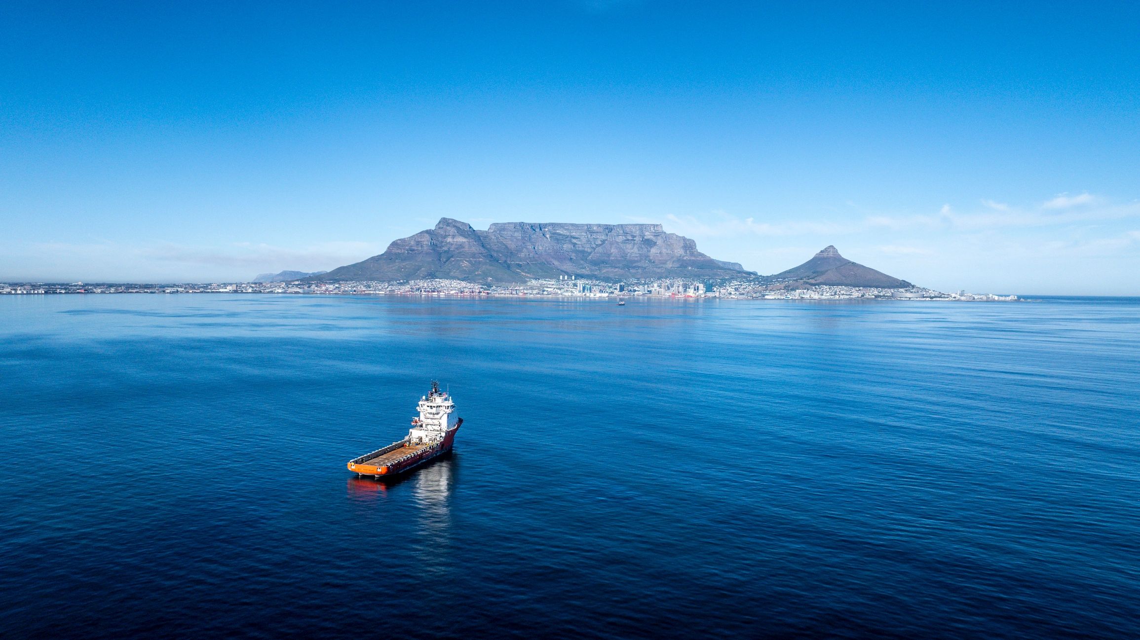 Schiff vor dem Hafen von Kapstadt mit Tafelberg im Hintergrund